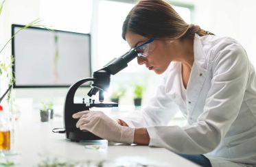 Une femme regardant dasn un microscope